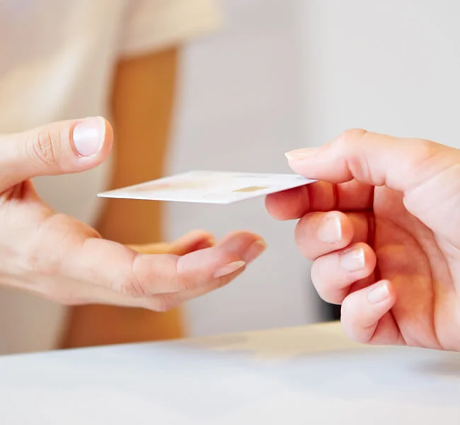 Personnel administratif d'IRIFIV remettant une carte bancaire à un patient après les formalités de sortie